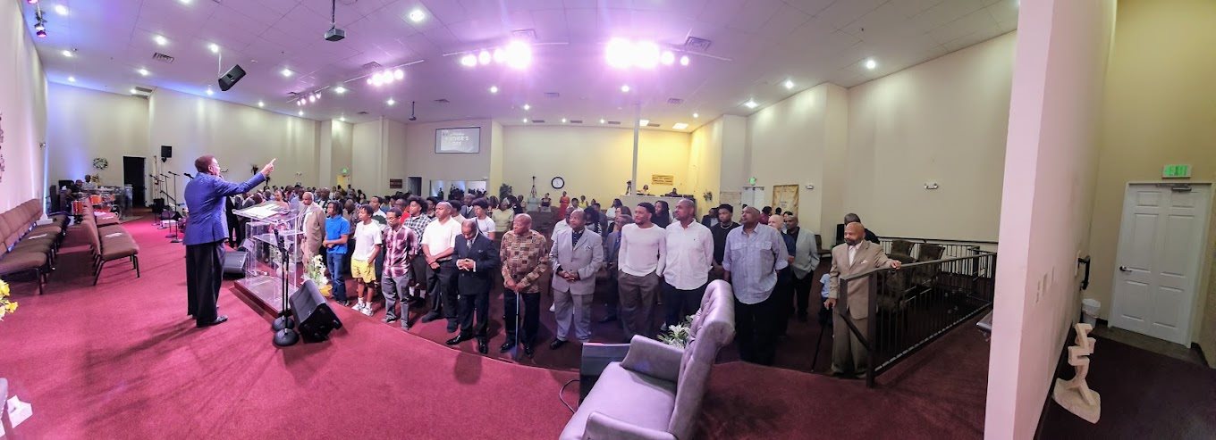 Men of Emmanuel Christian Center standing together in worship